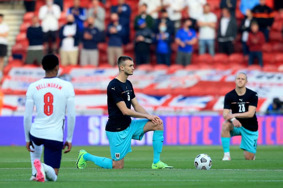England's Jude Bellingham and Austria’s Sasa Kalajdzic take the knee before kick-off