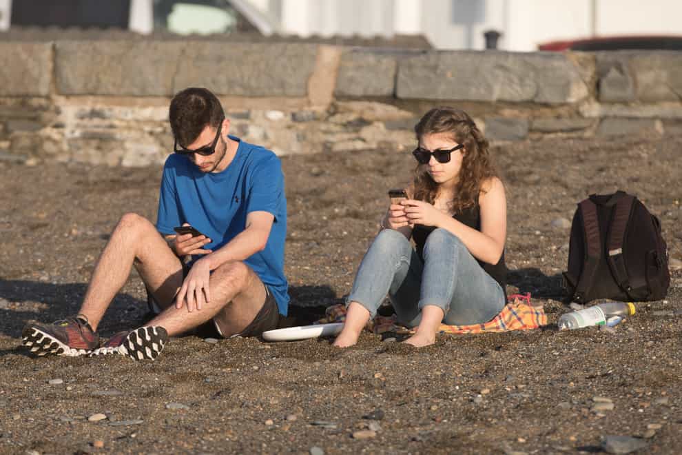 People using phone on the beach