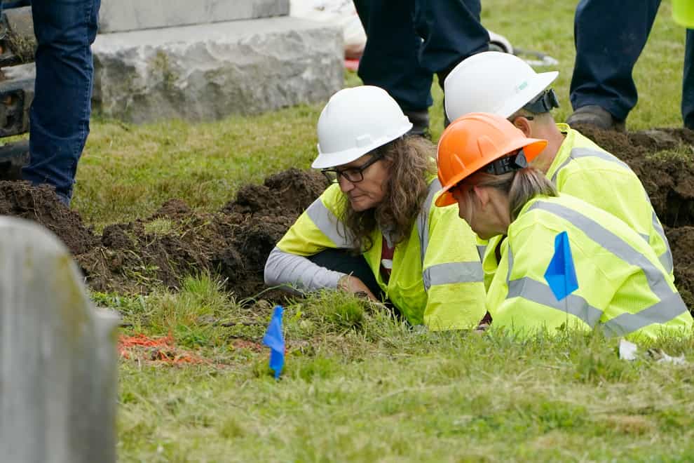 Oklahoma state archaeologist Kary Stackelbeck, left, examines the digging site as excavation begins at Oaklawn Cemetery in a search for victims of the Tulsa Race Massacre (Sue Ogrocki/AP)