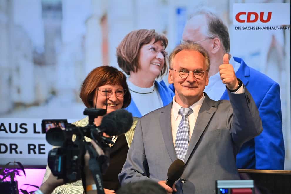 Saxony-Anhalt state governor Reiner Haseloff of Angela Merkel’s Christian Democratic Union party, CDU, and his wife Gabriele react, at the CDU election party (Bernd Von Jutrcznka/AP)
