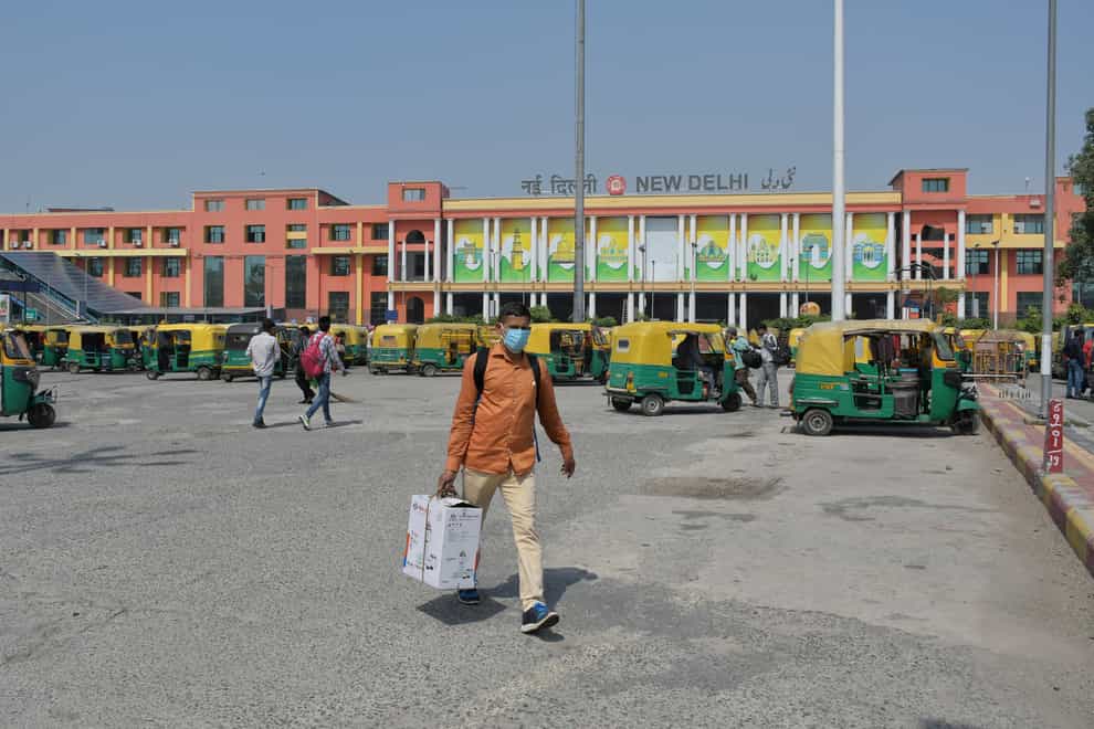 Passengers walk outside the New Delhi railway station in India