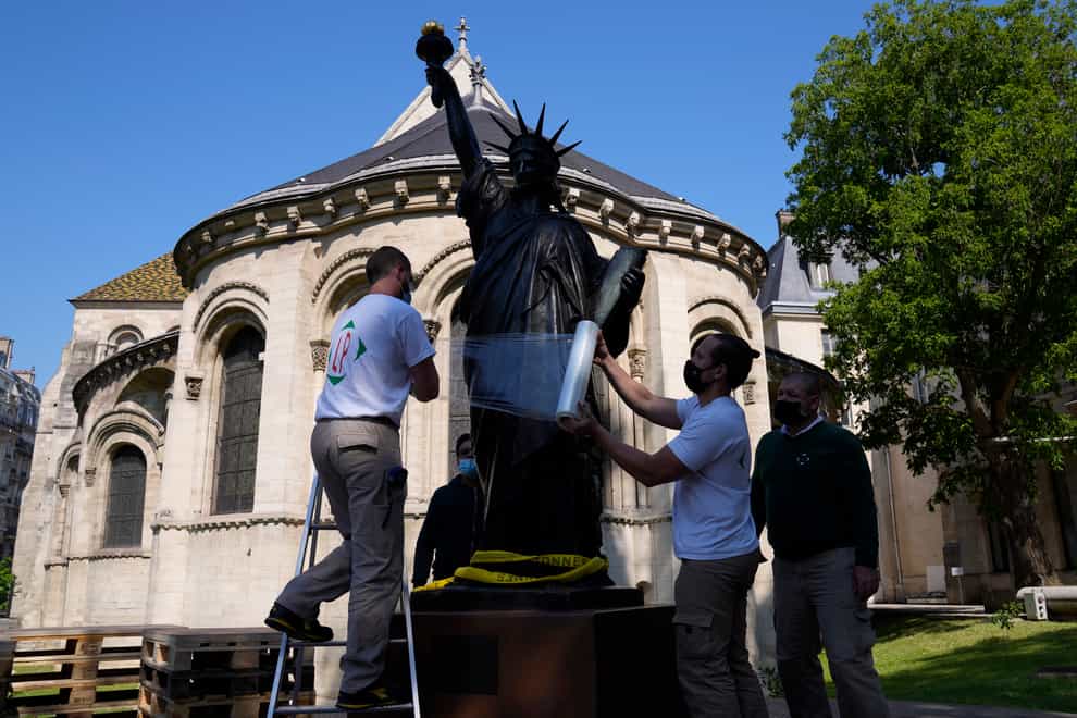Workers prepare the Liberty Enlightening the World by Frederic Auguste Bartholdi, a mini-replica of the French-designed Statue of Liberty, in Paris (Francois Mori/AP)