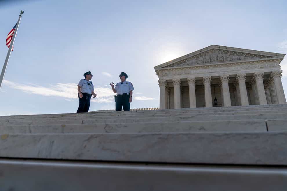 Police officers talk in front of the Supreme Court in Washington (Andrew Harnik/AP)