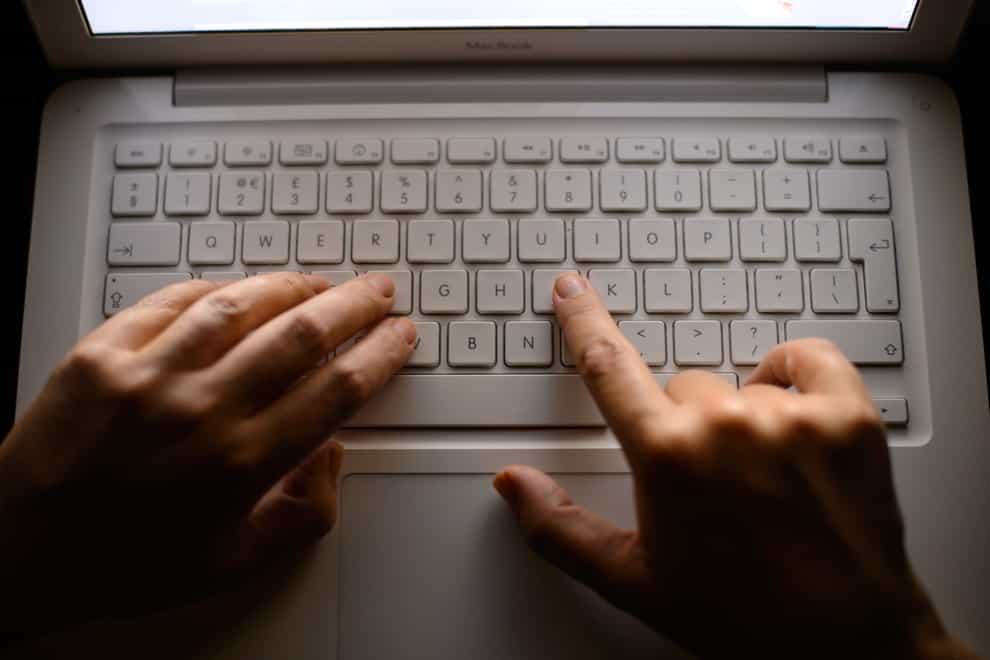 Hands over laptop keyboard