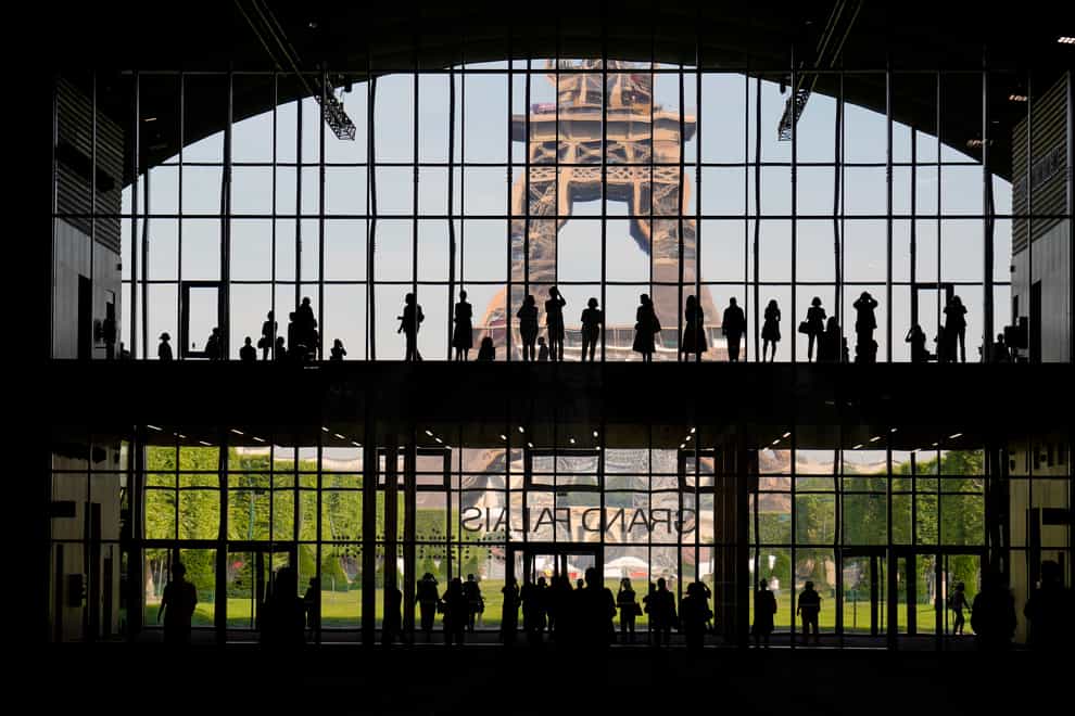 Visitors gather during a presentation visit of the Grand Palais Ephemere, with the Eiffel Tower seen outside (Francois Mori/AP)