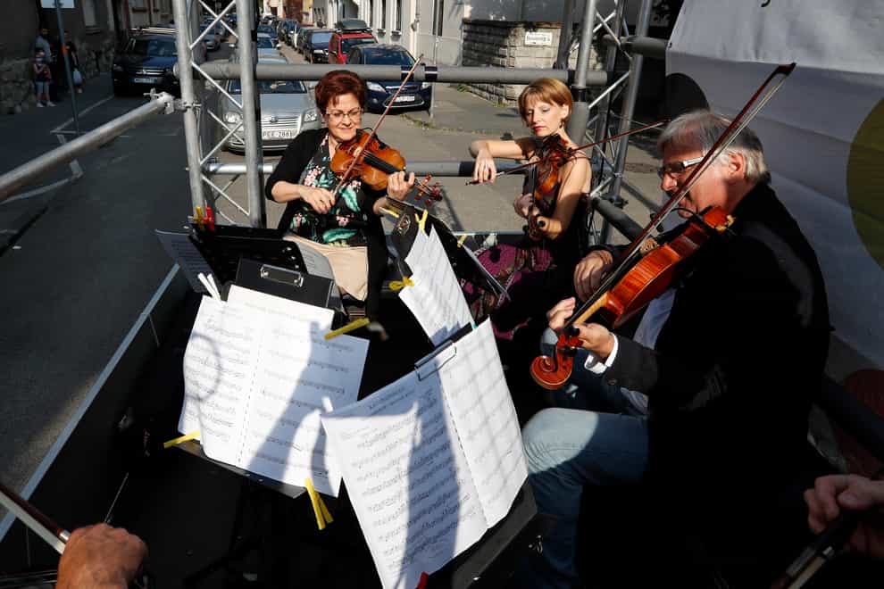 Members of the Budapest Festival Orchestra play music on the back of a truck