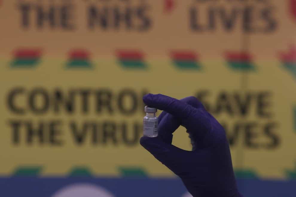 Nurse holds up vaccine vial