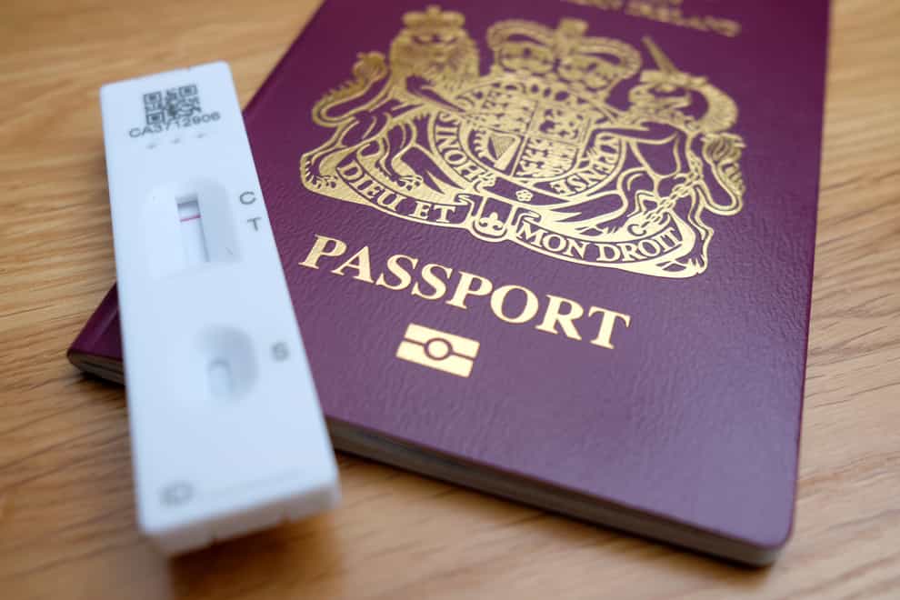A negative Covid-19 test sits on top of a Passport for the United Kingdom of Great Britain and Northern Ireland. (Andrew Matthews/PA)