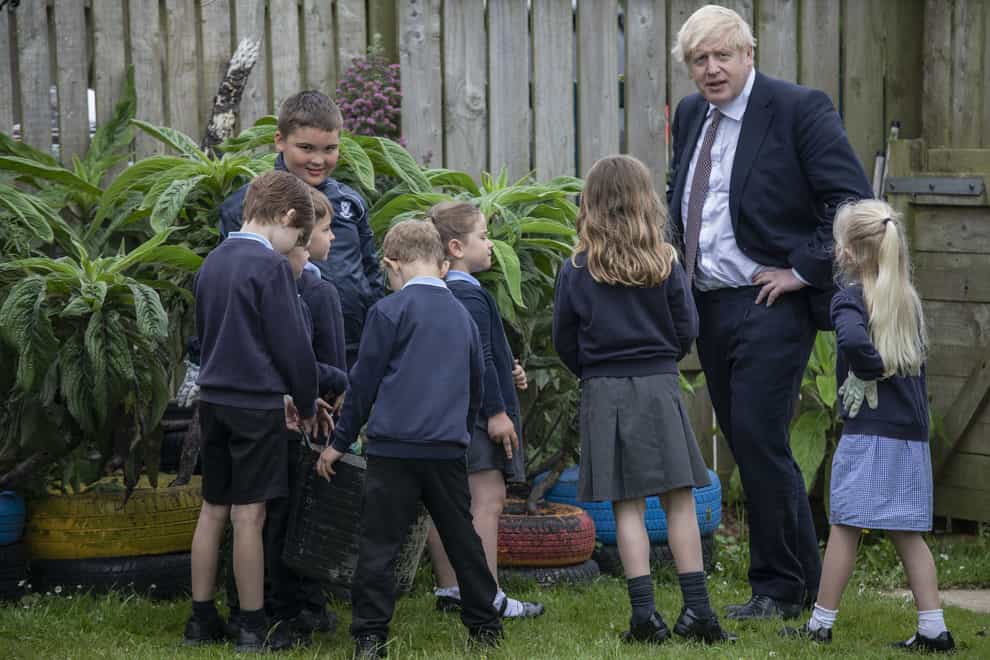 Prime Minister Boris Johnson talks with primary school children in the outdoor spaces at the St Issey C of E Primary school near Wadebridge in Cornwall (Jack Hill/The Times/PA)
