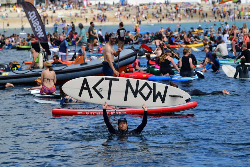 Protesters take part in a paddle out, organised by Surfers Against Sewage, on Gyllyngvase Beach near Falmouth