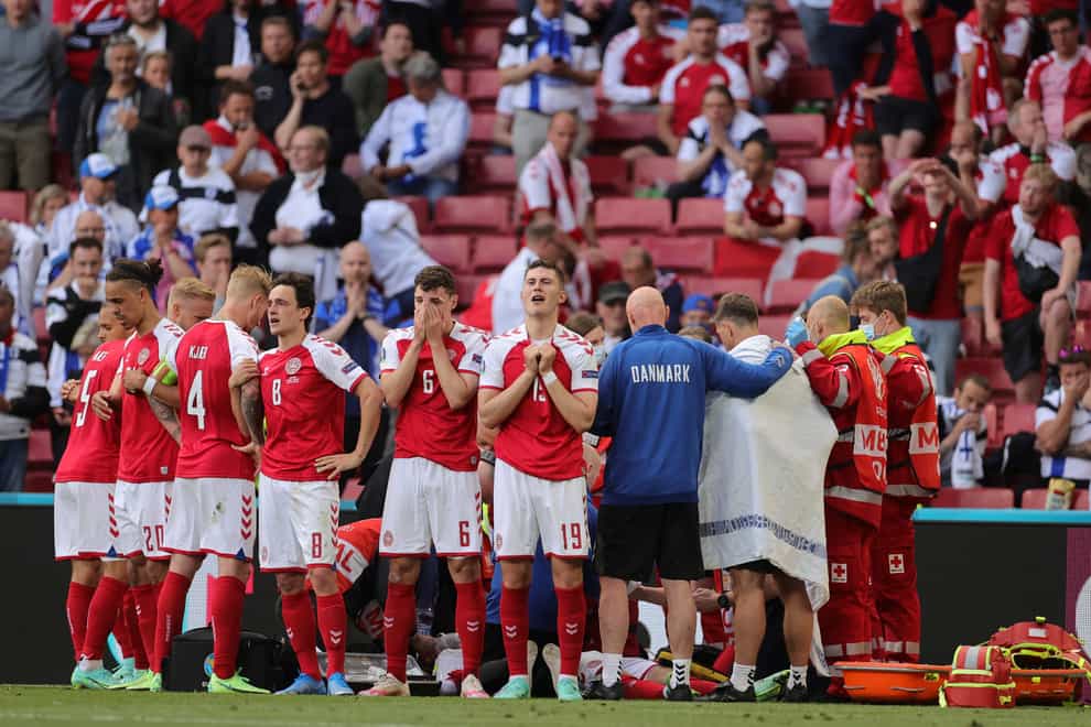 Denmark players form a protective ring while Christian Eriksen receives treatment
