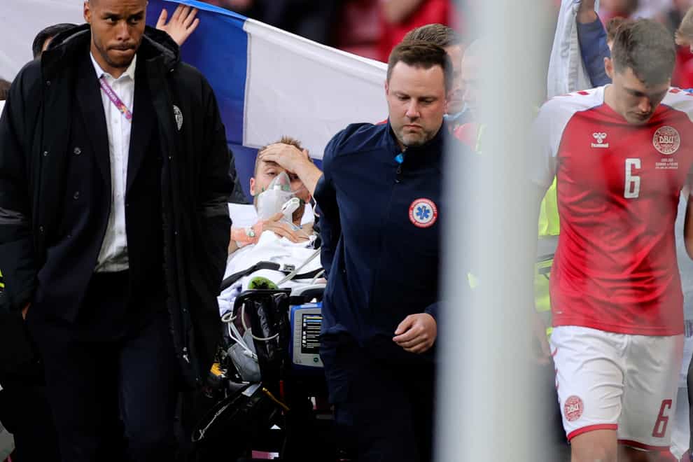 Paramedics use a stretcher to take Denmark’s Christian Eriksen off the pitch