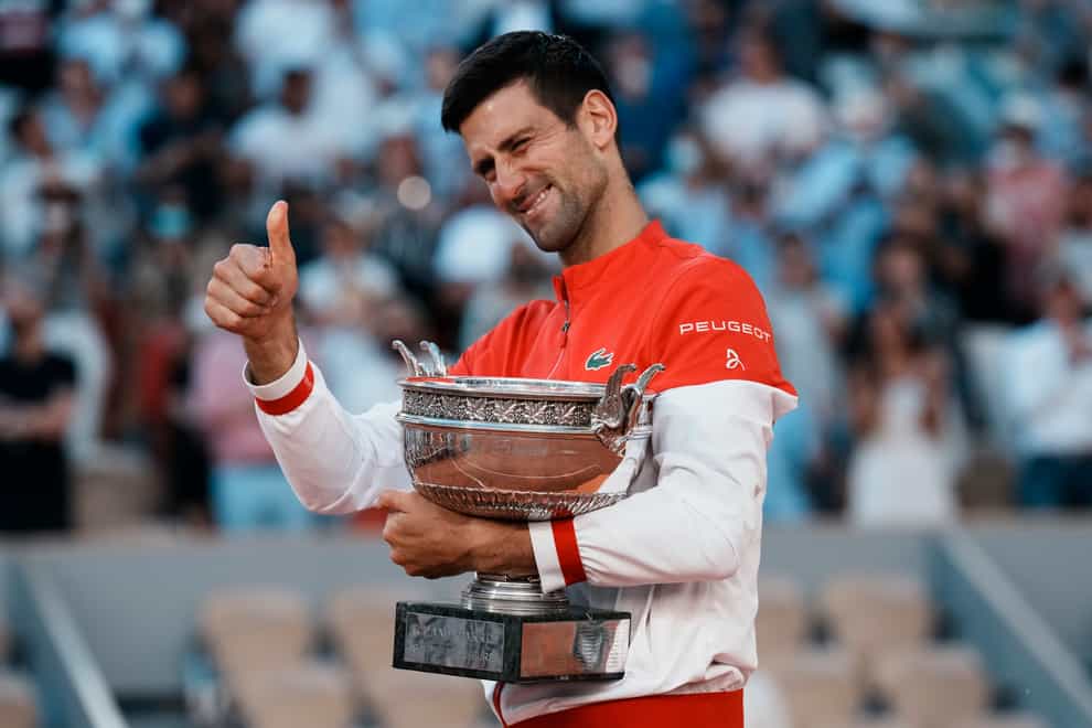 Novak Djokovic gives a thumbs up as he holds the Coupe des Mousquetaires