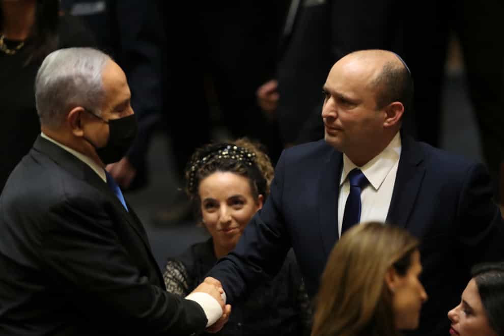 Israel PoliticsIsrael’s new prime minister Naftali Bennett shakes hands with outgoing prime minister Benjamin Netanyahu during a Knesset session in Jerusalem (Ariel Schalit/AP)