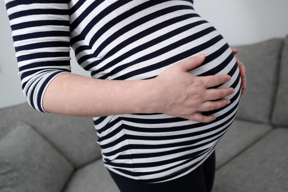 A pregnant woman holds her stomach