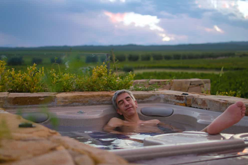 Smiling man relaxing in an outdoor jacuzzi