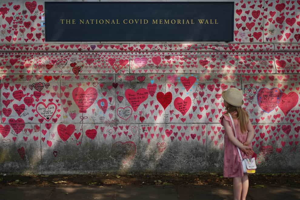 A child looks at the National Covid Memorial Wall in London