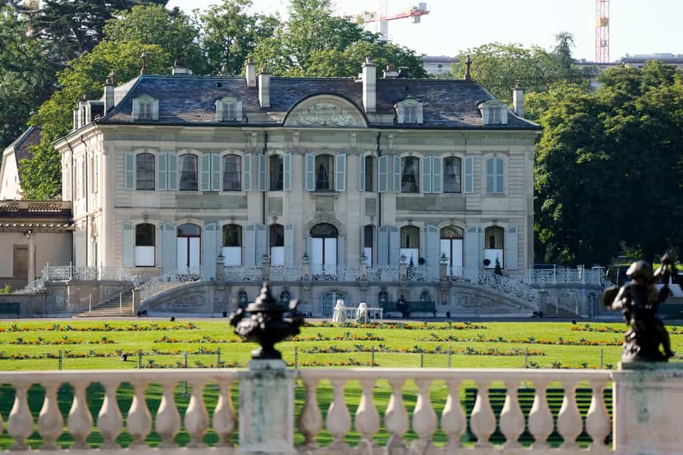 A police officer sits in front of the Villa la Grange in Geneva ahead of the summit