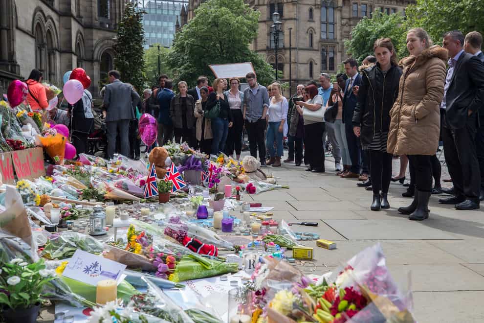 People look at flowers outside the Town Hall in Manchester