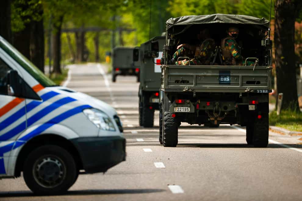 Belgian military ride in a convoy at the entrance of the National Park Hoge Kempen during a manhunt for an armed soldier in Maasmechelen, Belgium (Francisco Seco/AP)