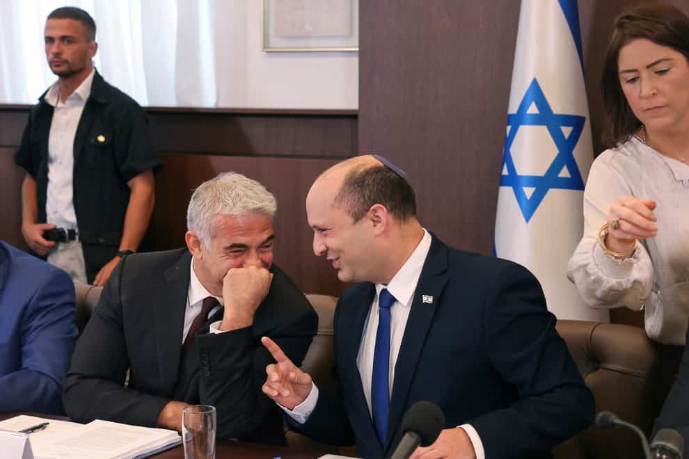 Israeli prime minister Naftali Bennett, right, shares a joke with alternate prime minister and foreign minister Yair Lapid (Emmanuel Dunand/AP)