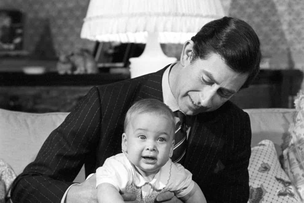 <p>The Prince of Wales cradles his son Prince William at Kensington Palace in 1982</p>