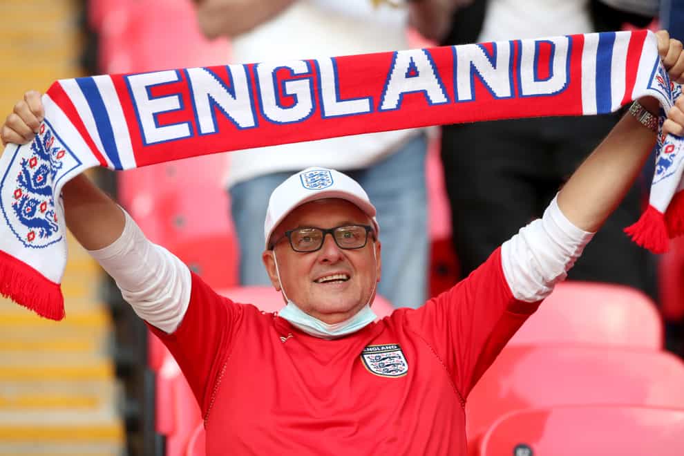 <p>An England fan holding a scarf in the stands at Wembley Stadium</p>