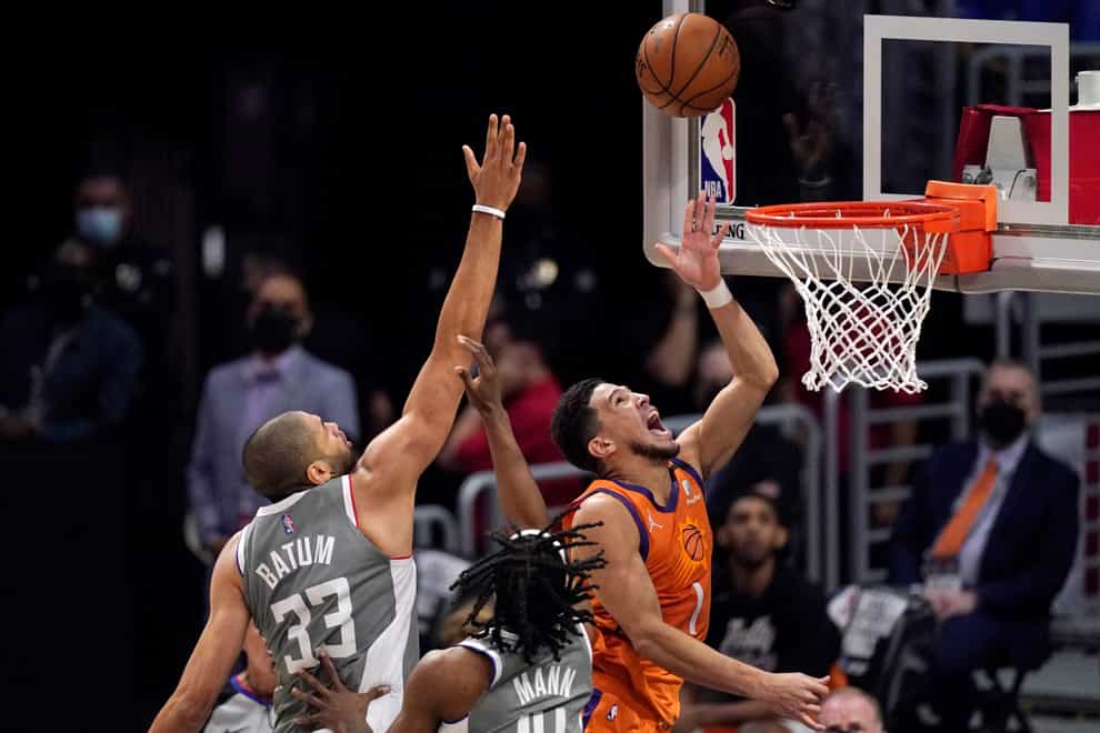 Phoenix Suns guard Devin Booker, right, shoots as Los Angeles Clippers forward Nicolas Batum defends