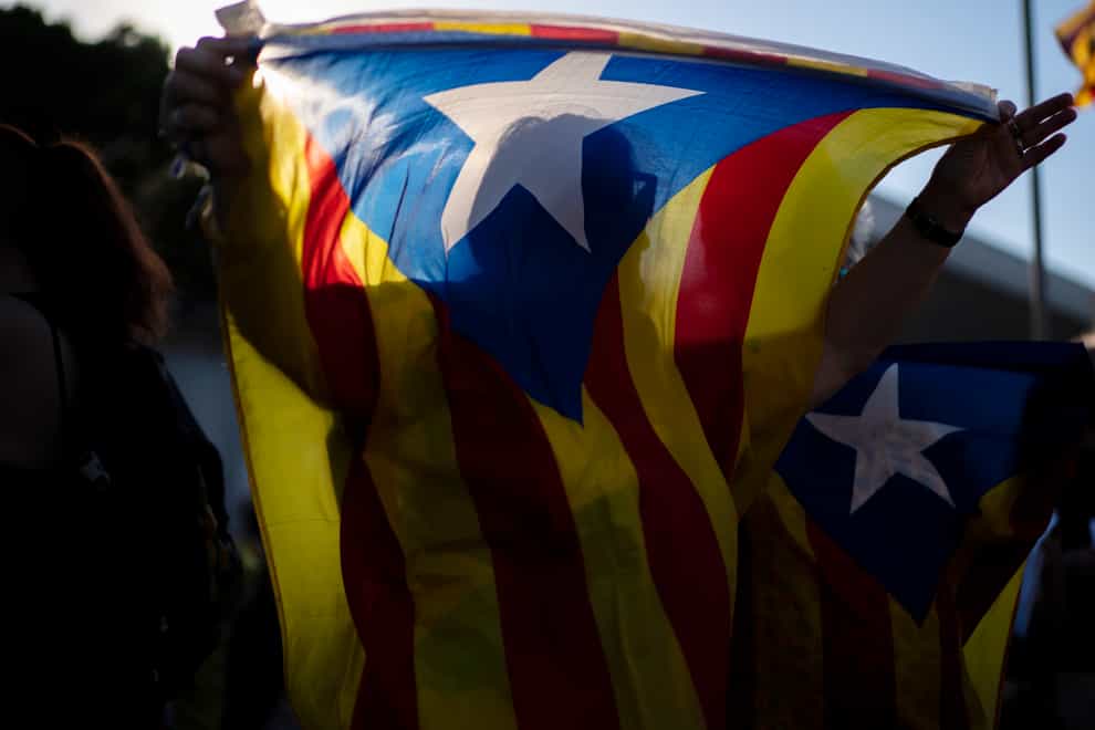 A protester holds an Estelada pro-independence flag during a protest against the visit of Spain’s King Felipe VI to Barcelona, Spain (Joan Mateu/AP)