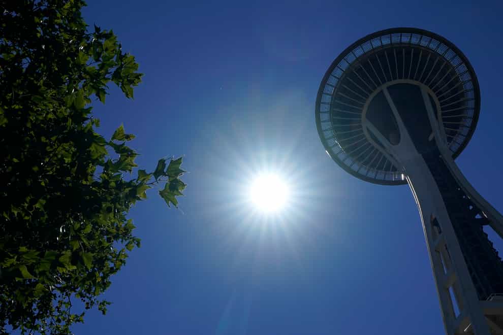 The sun shines near the Space Needle, Monday, June 28, 2021, in Seattle