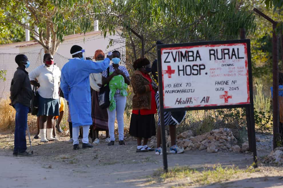 Residents of Zvimba, in rural Zimbabwe, have their temperatures taken before seeking treatment at the local hospital
