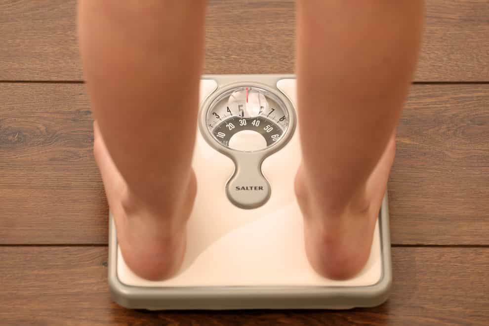 A person using a set of weighing scales
