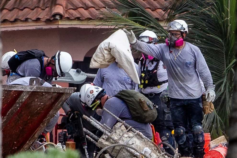 A rescuer finds a pillow as search and rescue teams look for survivors