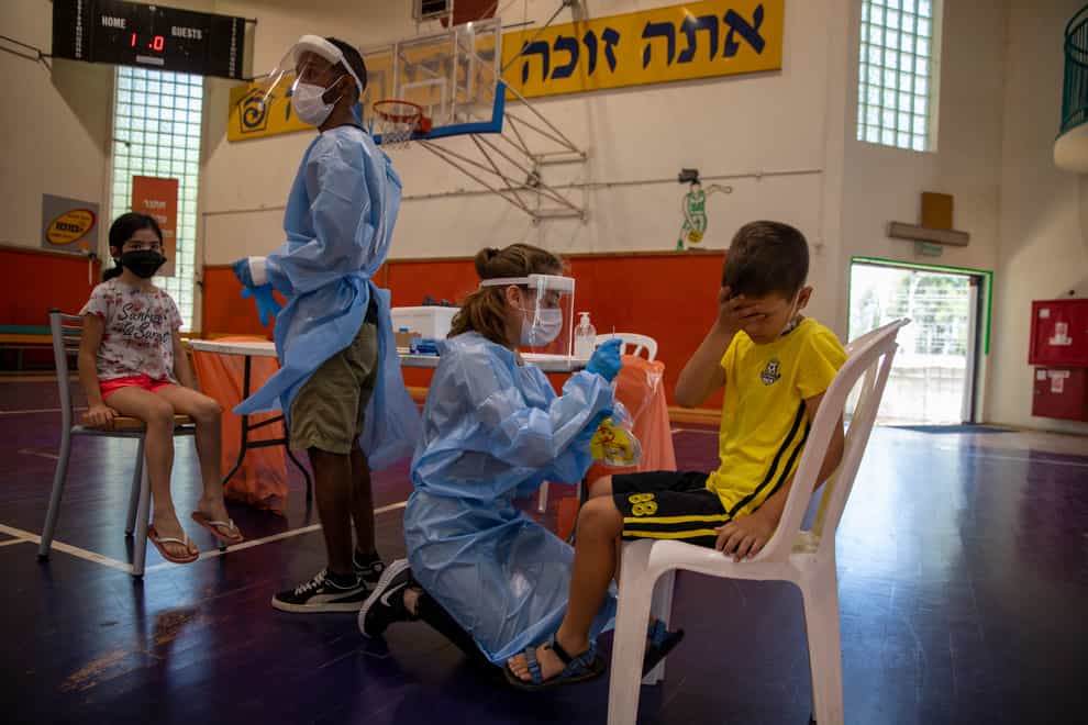 Medical personnel test children for coronavirus in Israel