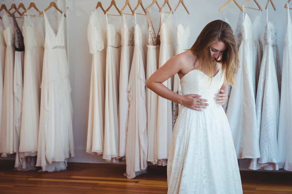 <p>Woman trying on wedding dress in a shop</p>