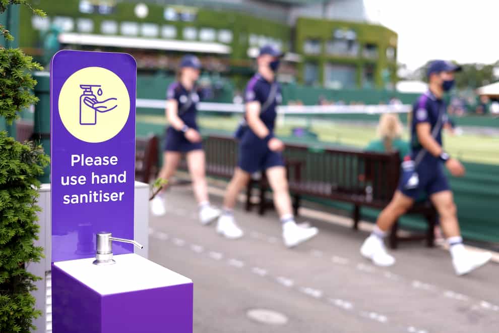 Ball boys and girls walk past a hand sanitiser station outside court 8 of Wimbledon at The All England Lawn Tennis and Croquet Club, Wimbledon (Steven Paston/PA)