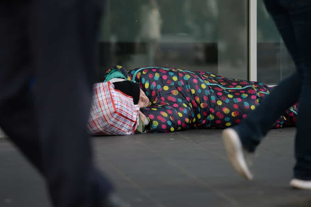People walking past a homeless man in London