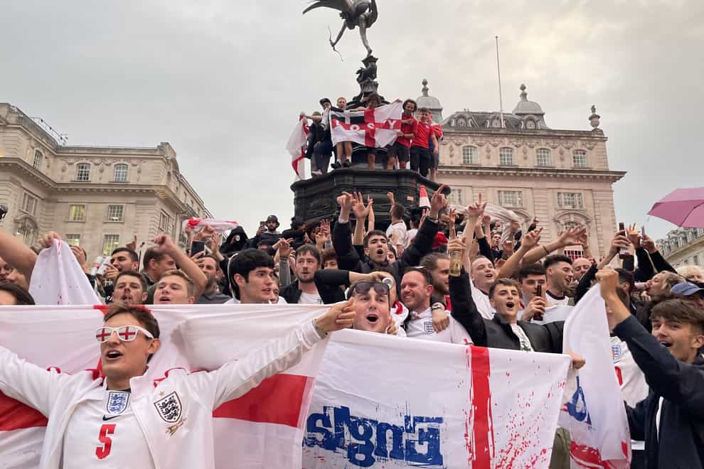 England football fans climb the statue of Eros in Piccadilly Circus