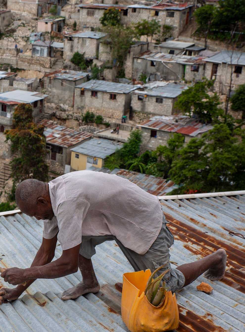 Antony Exilien secures the roof of his house in response to Tropical Storm Elsa in Port-au-Prince, Haiti