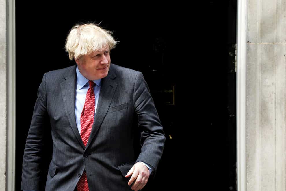 <p>Prime Minister Boris Johnson walks through a doorway</p>