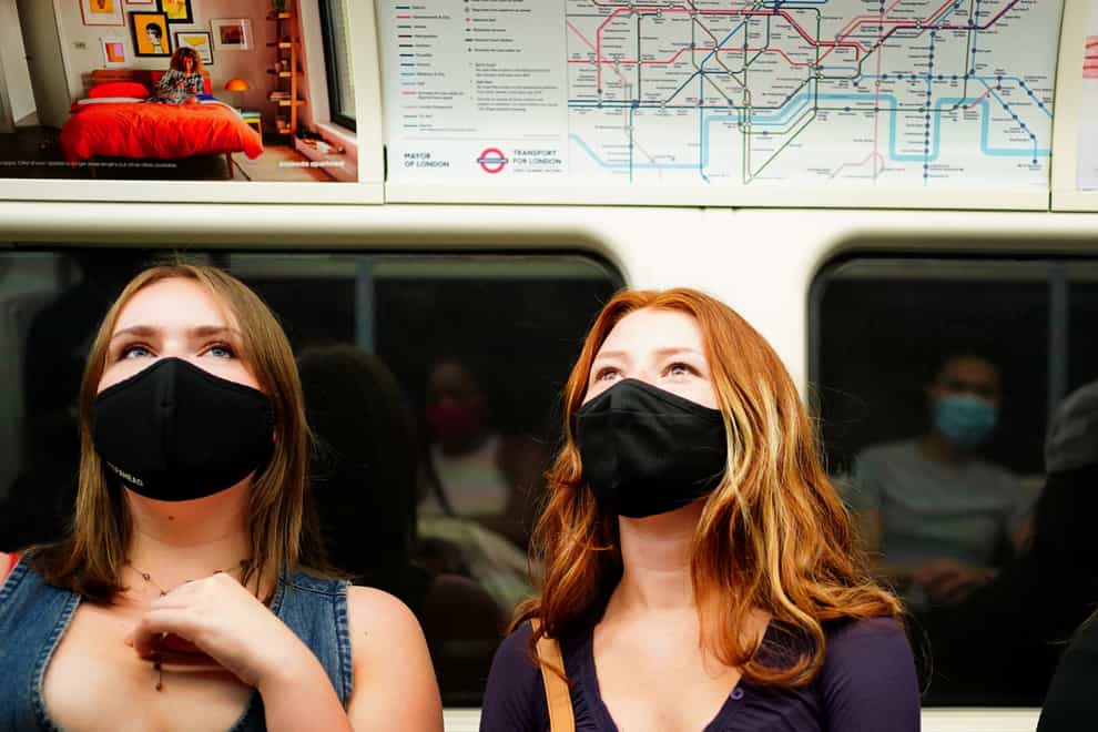 Two women wearing face masks on the Tube