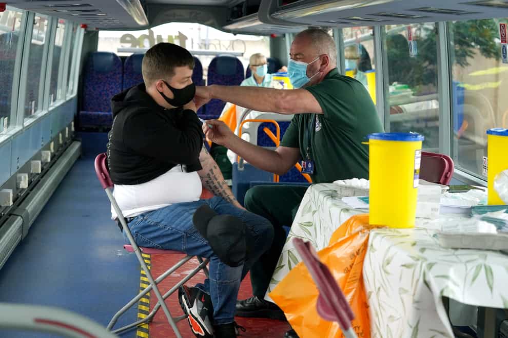 Paramedic Tom Watt gives a first vaccination to Matthew Orr on board a Covid vaccination bus at the Forge shopping centre in Glasgow