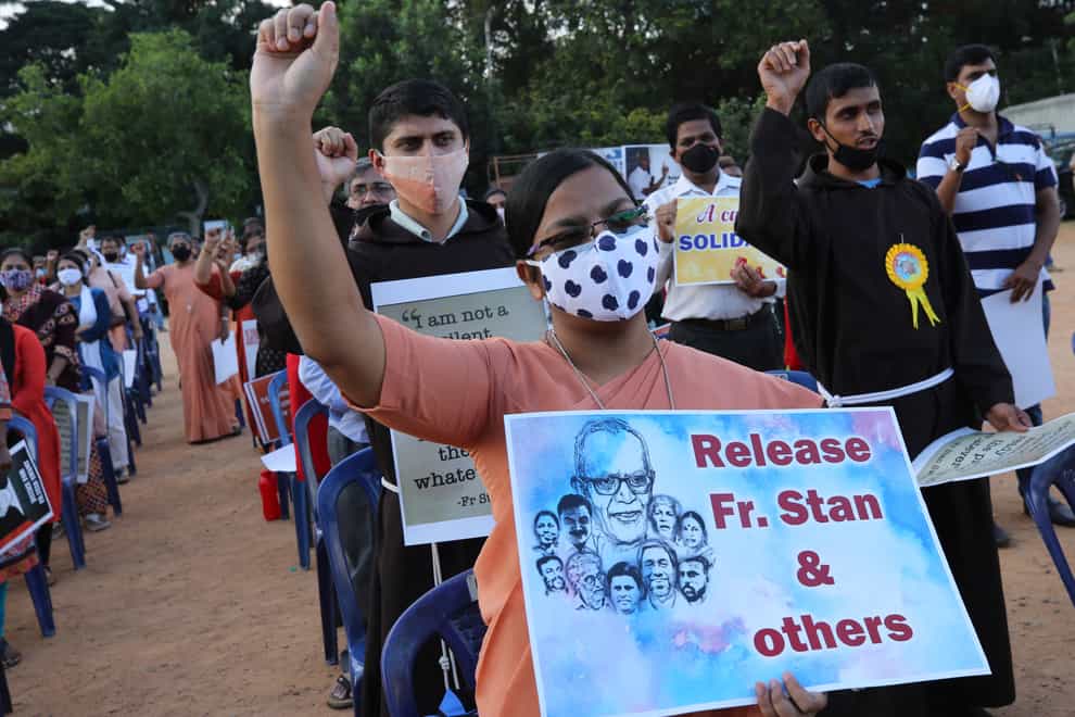 A Christian nun, centre, holds a placard and shouts slogans with others demanding the release of tribal rights activist Stan Swamy and other activists during a demonstration in Bengaluru, India (Aijaz Rahi/AP)