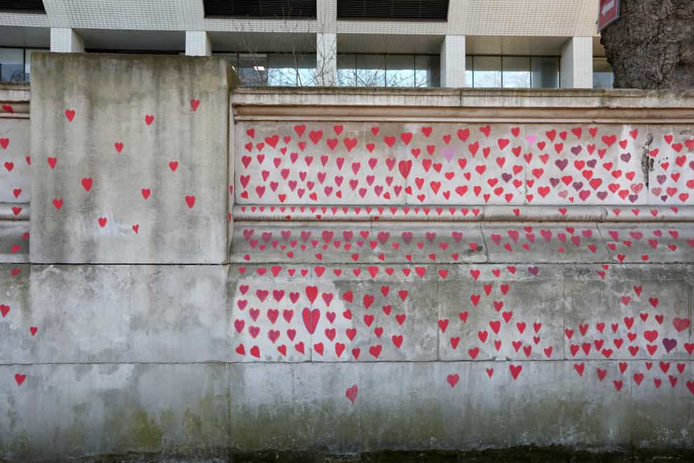 Red hearts painted by members of bereaved families on the Covid-19 Memorial Wall opposite the Houses of Parliament