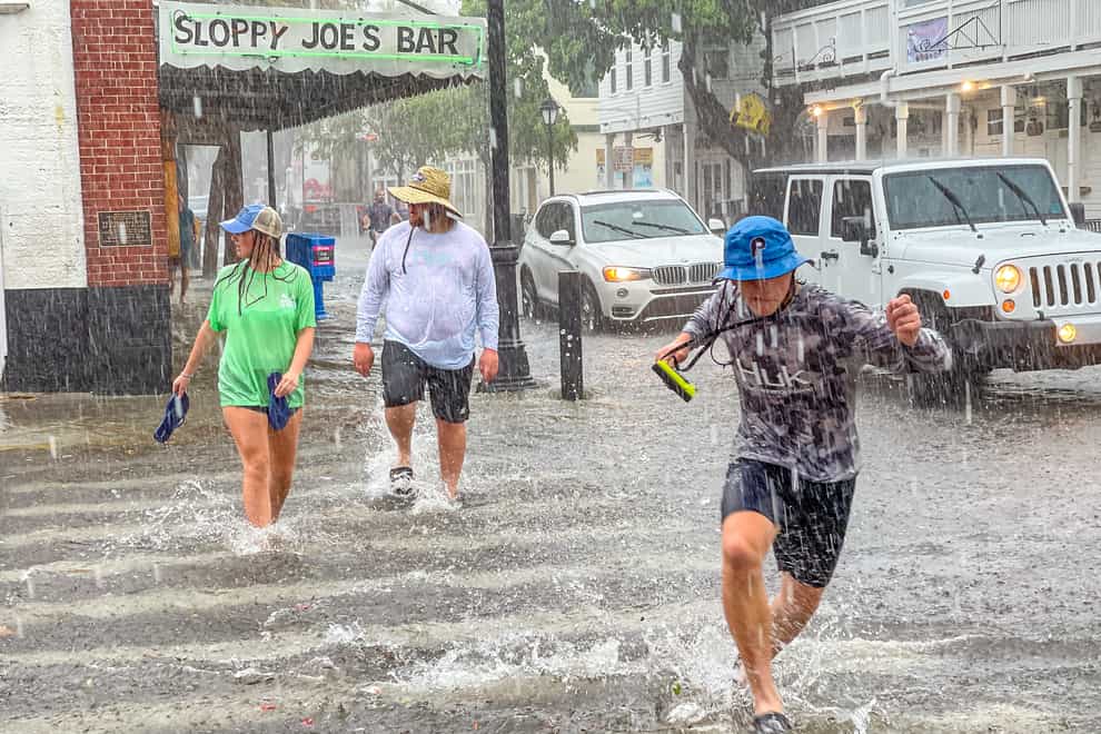 People run across flooded streets in Florida