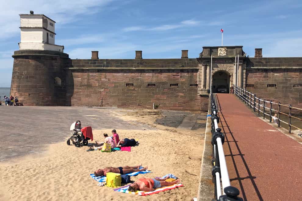 <p>People sun bathing in New Brighton in Merseyside</p>