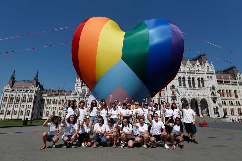 Activists pose for a photo after erecting a large rainbow-coloured heart in front of the country’s parliament building in Budapest, Hungary (Laszlo Balogh/AP)