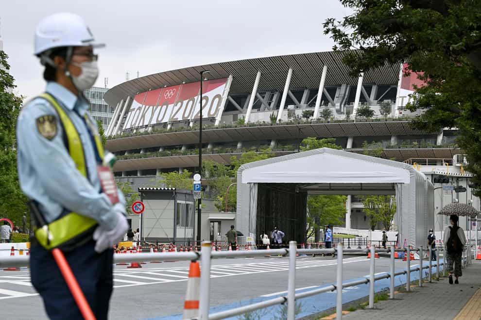 A security guard wearing face masks guards outside the National Stadium in Tokyo (Shinji Kita/AP)
