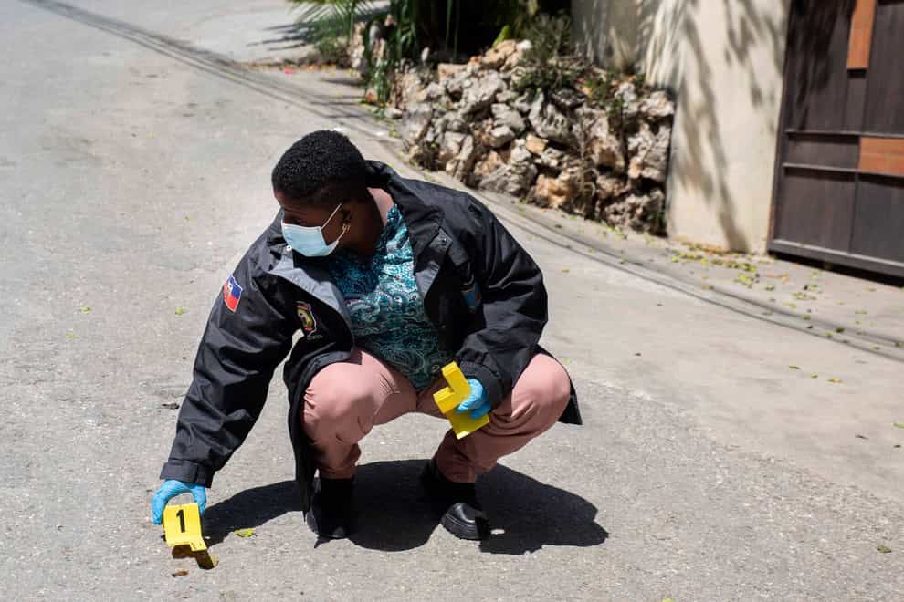 An investigator places an evidence marker next to a bullet casing (Joseph Odelyn/AP)