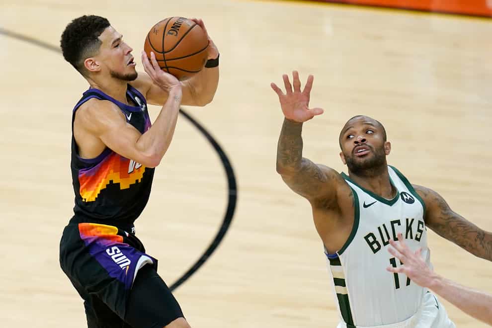 Phoenix Suns guard Devin Booker, left, shoots against Milwaukee Bucks forward PJ Tucker